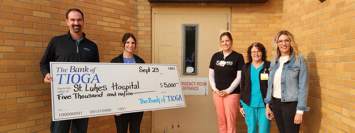 The Bank of Tioga employees donate check to St. Luke em